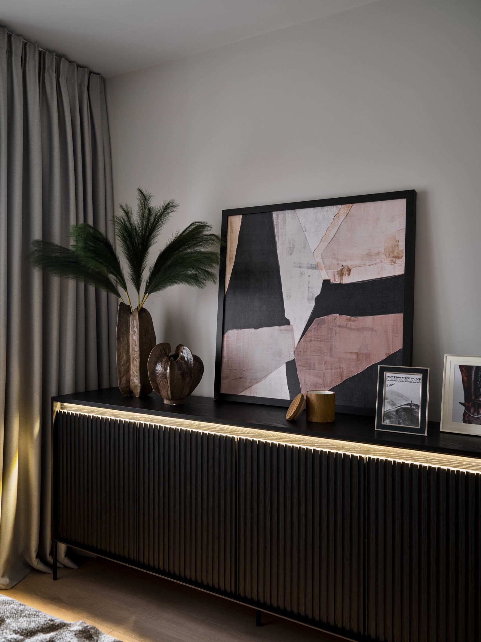 Bedroom storage with black fluted cabinetry and soft curtains