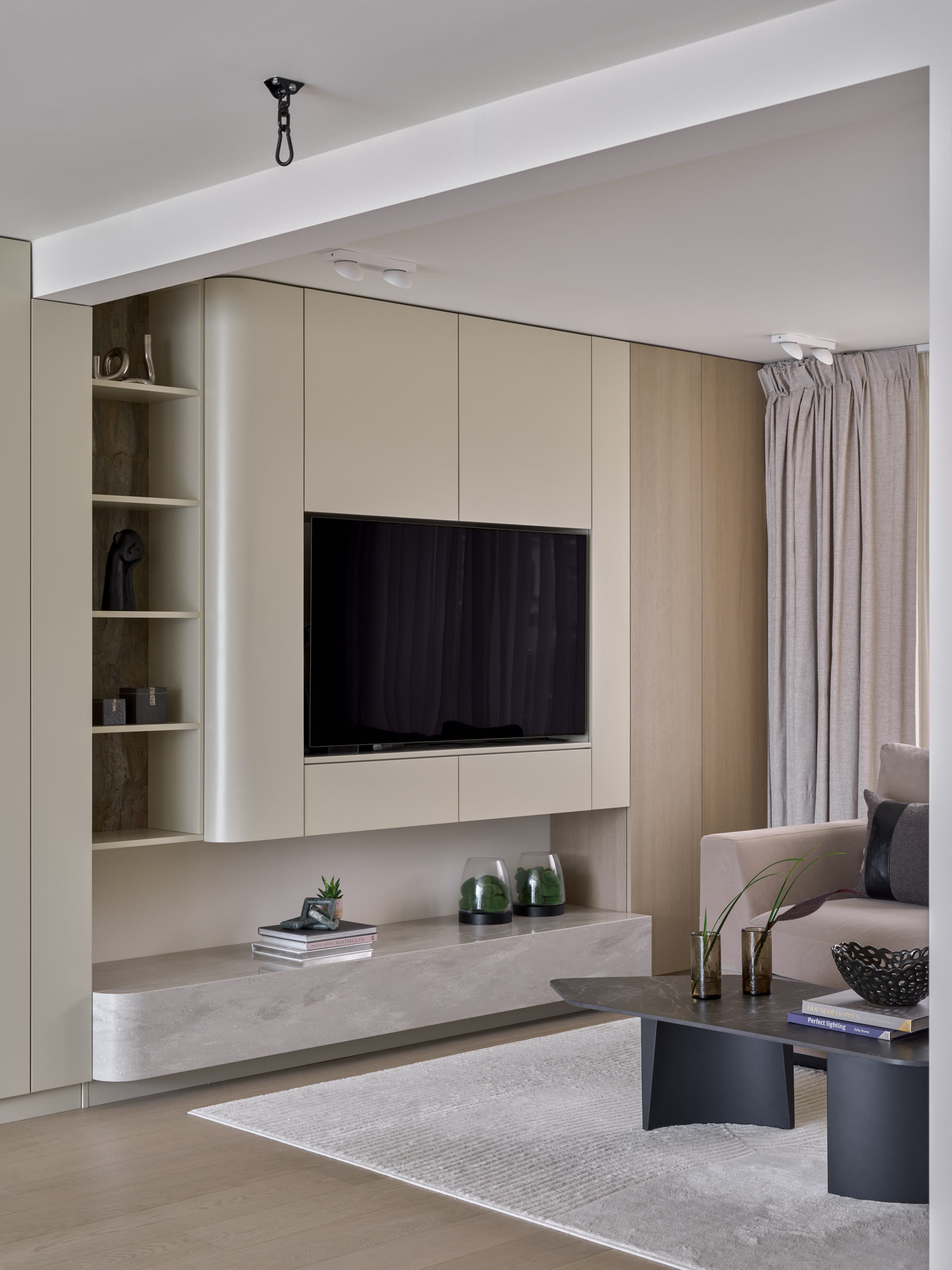 Black sideboard with framed artwork and ceramic vessels in a contemporary London living room