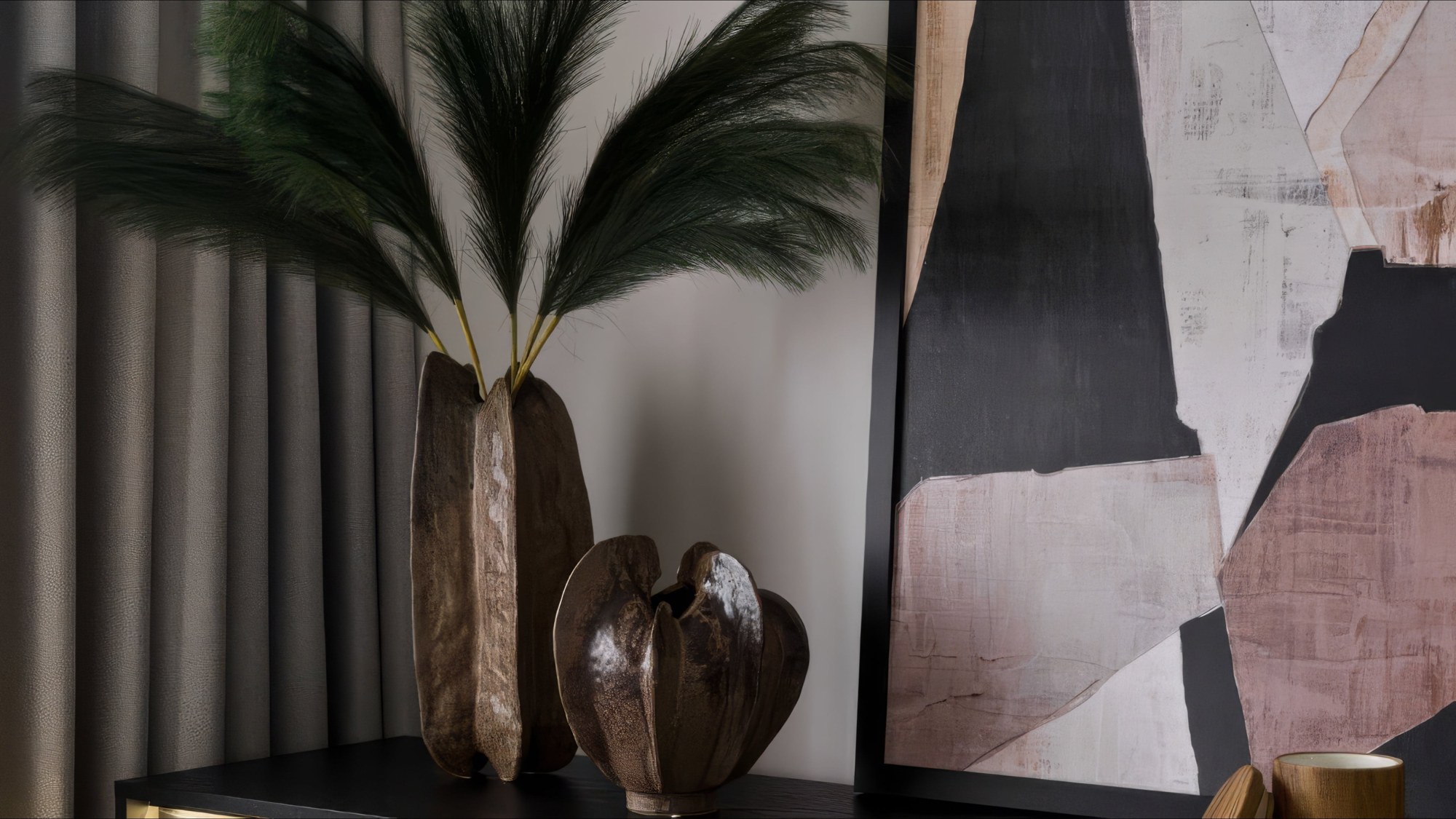 Sculptural ceramic vases with pampas grass beside abstract artwork, styled by Studio 32
